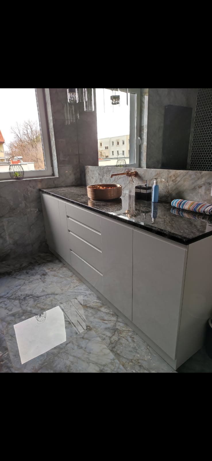 Nowoczesna kuchnia z marmurowymi blatami i dużym oknem