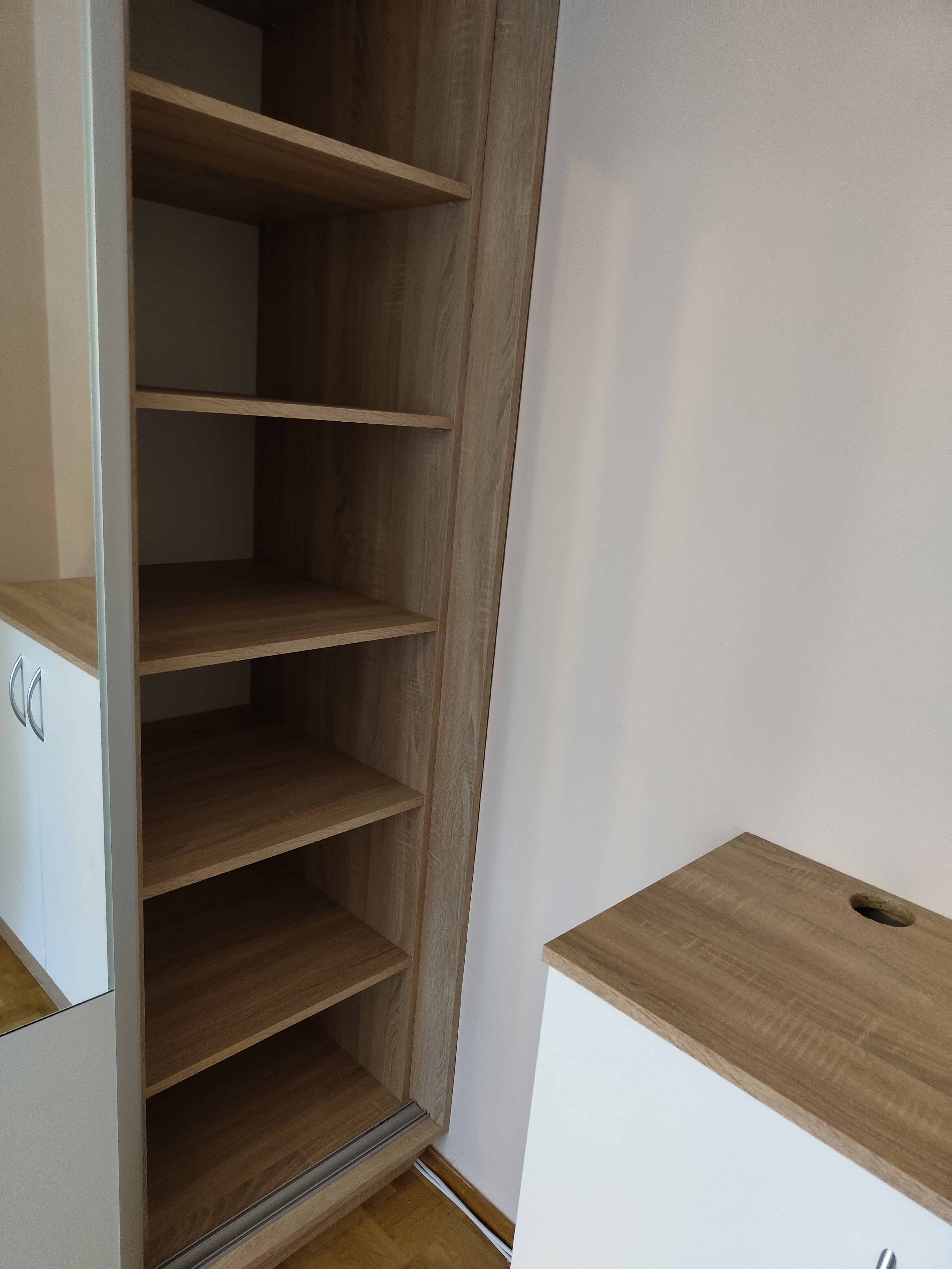 Nowa szafa z półkami i biurko w nowoczesnym wnętrzu