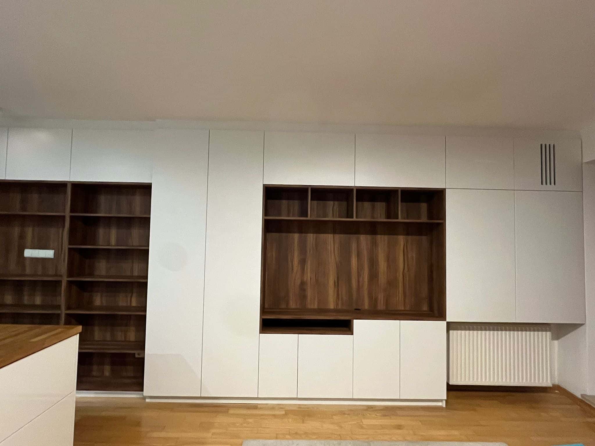Nowe białe i drewniane meble na ścianie w salonie