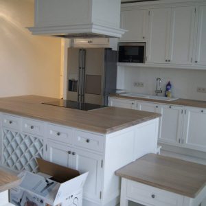 Jasna kuchnia z białymi szafkami i wyspą, nowoczesny design.